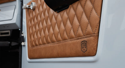 Quilted brown leather door panel with embossed CFB logo inside a Classic Ford Bronco