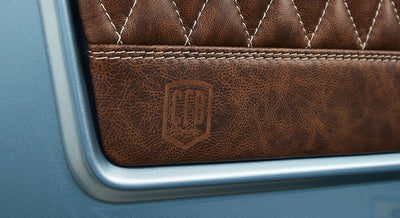 Close-up of embossed logo on brown leather panel inside Classic Ford Bronco
