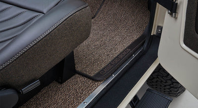 Classic Ford Bronco door sill with logo on floor mat and brown herringbone fabric