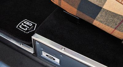 Close-up of floor mat with CFB logo and part of vehicle interior trim