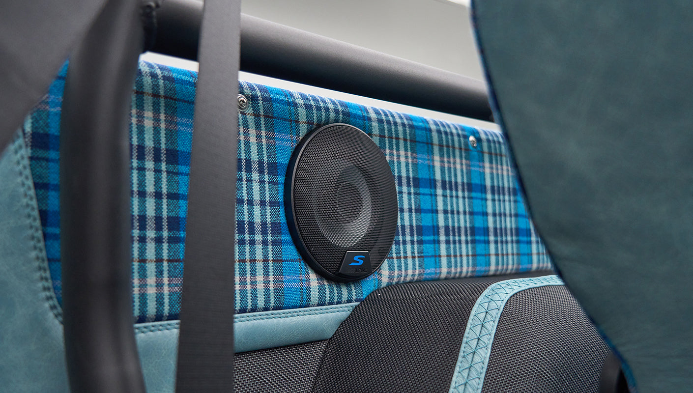 Close-up of speaker mounted on blue plaid fabric interior panel in Classic Ford Bronco