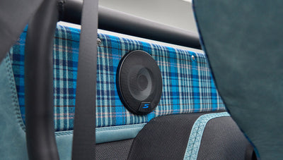 Close-up of speaker mounted on blue plaid fabric interior panel in Classic Ford Bronco