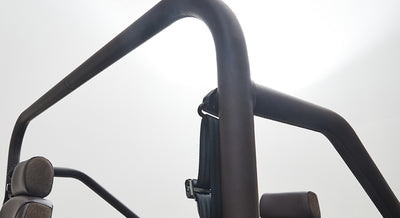 Black padded roll cage with visible seat headrests inside Classic Ford Bronco