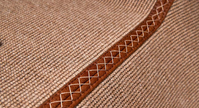 Close-up of beige carpet with stitched leather border detail inside Classic Ford Bronco