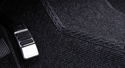 Black textured carpet inside vehicle with stitched edging detail