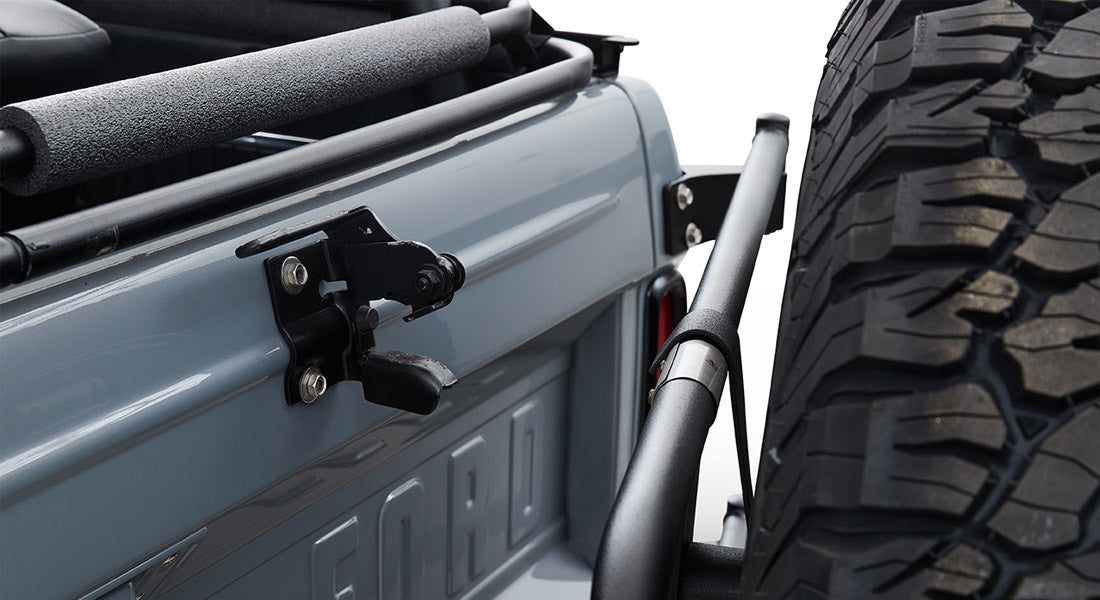 Rear section of a Classic Ford Bronco with spare tire mounted and visible tailgate latch