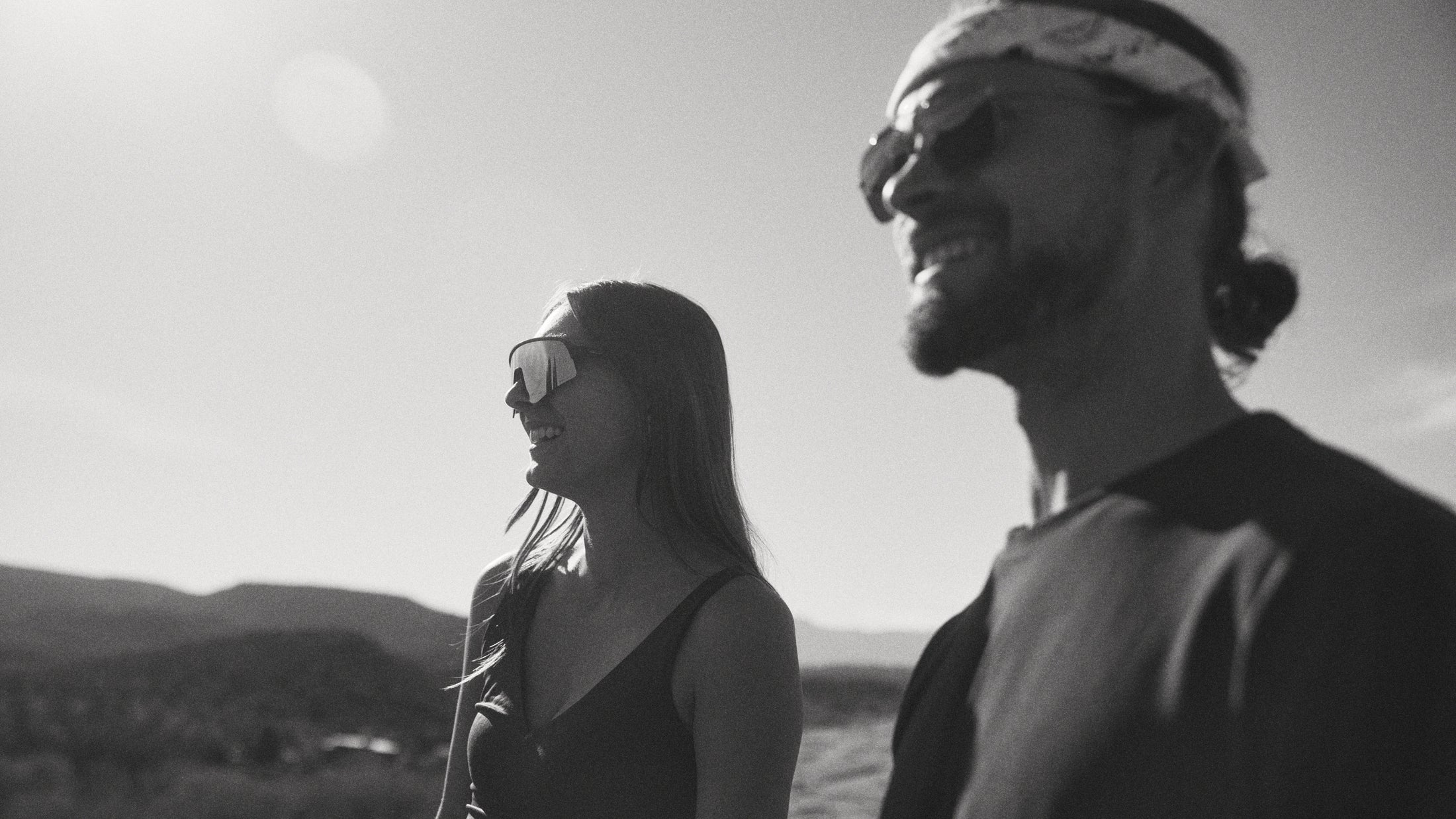 Black and white side profile of a man and woman smiling outdoors