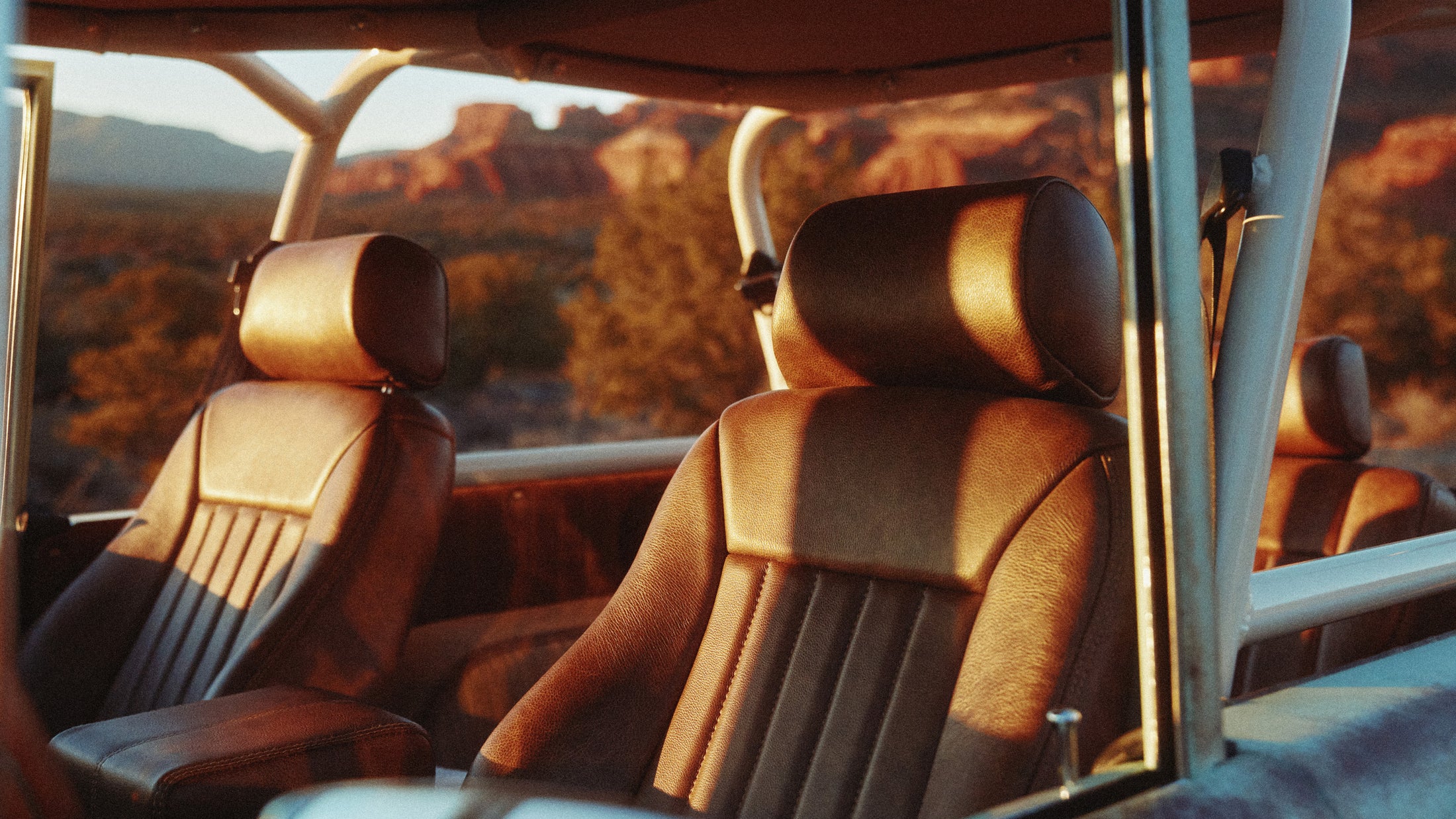 Interior view of a Classic Ford Bronco leather seats and roll cage at sunset