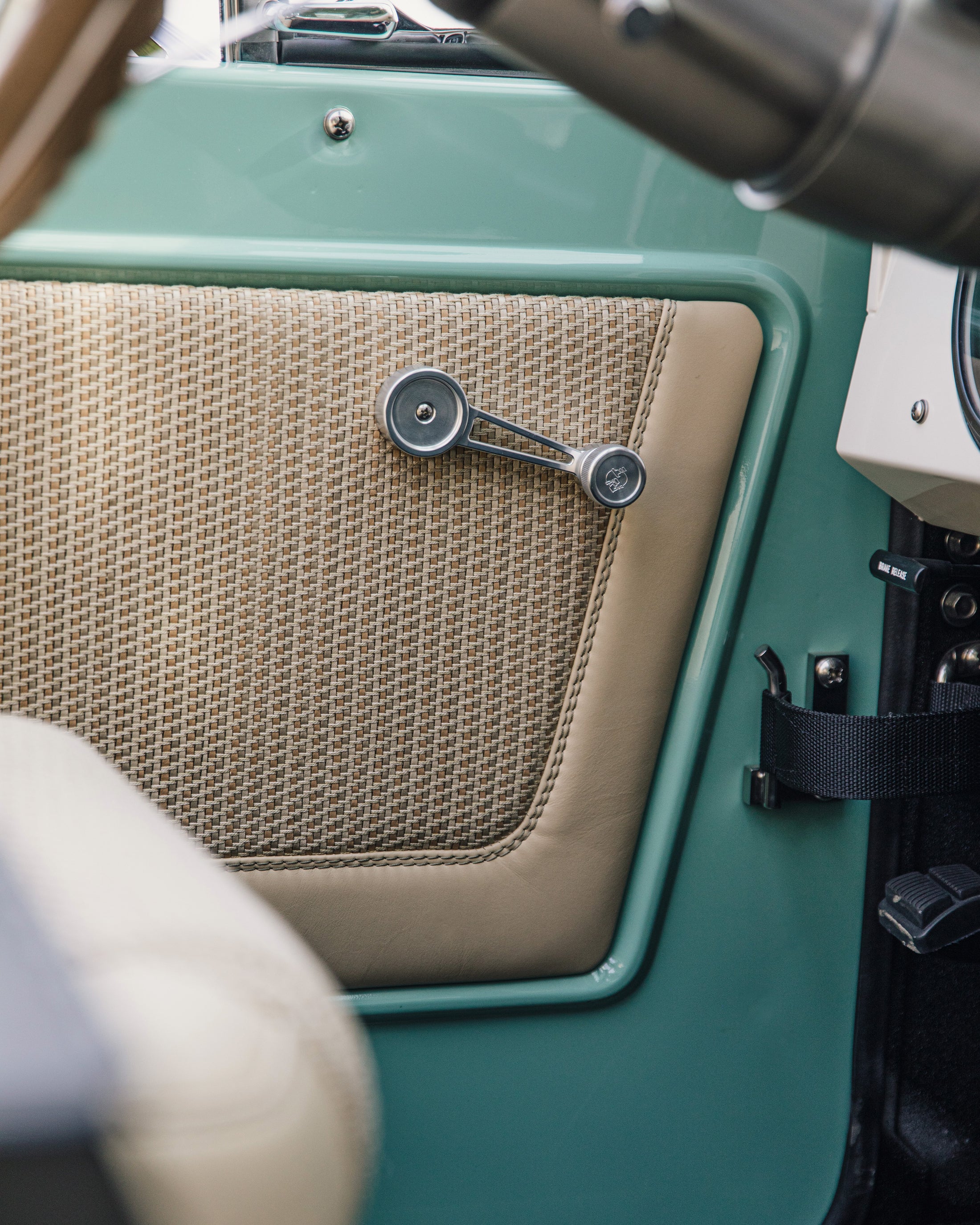 Classic Ford Bronco interior door panel with woven pattern and beige trim.