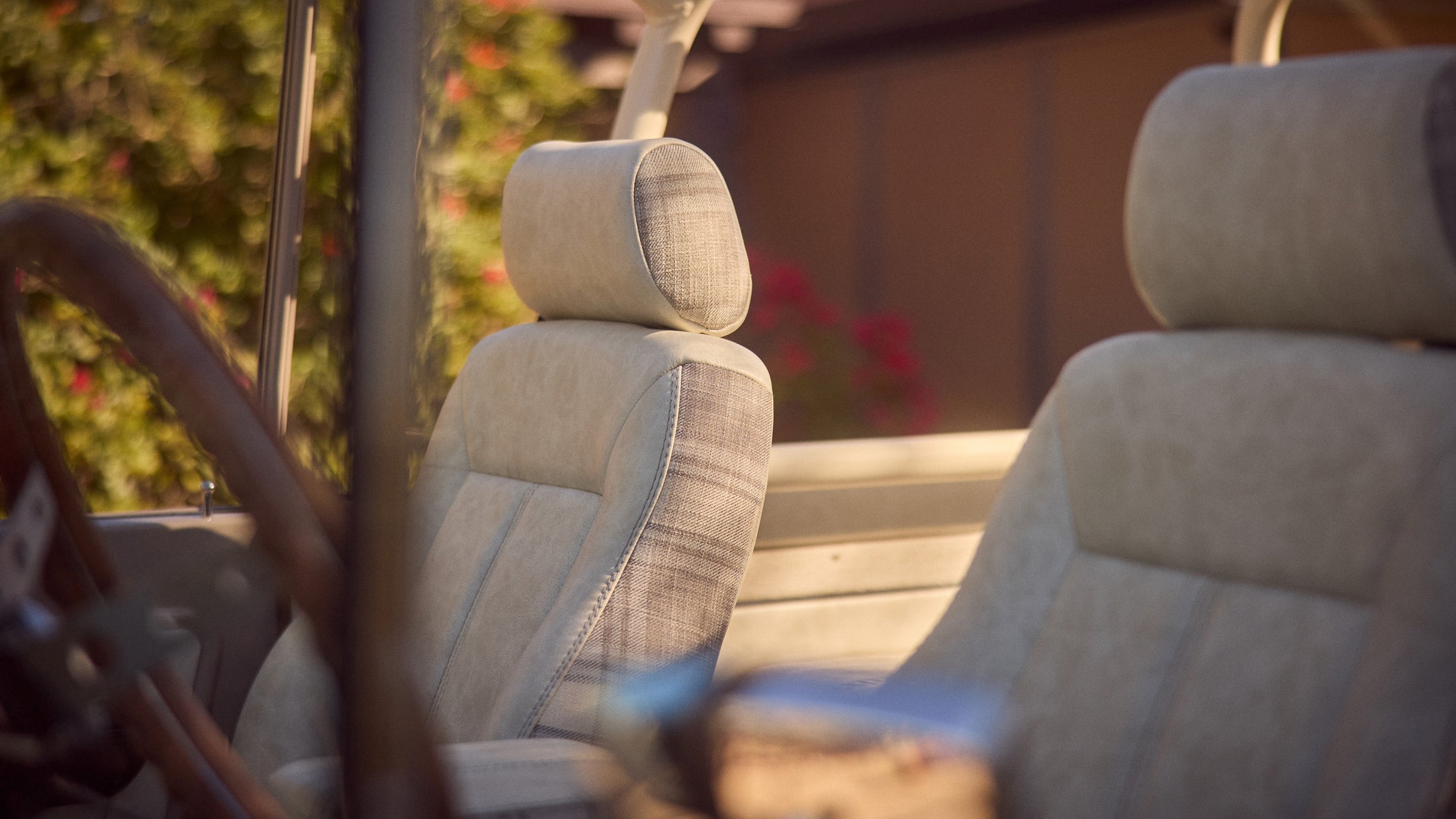 Close-up view of two light-colored upholstered seats in a vehicle