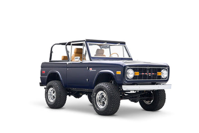 Blue Classic Ford Bronco with open top shown side profile on white background