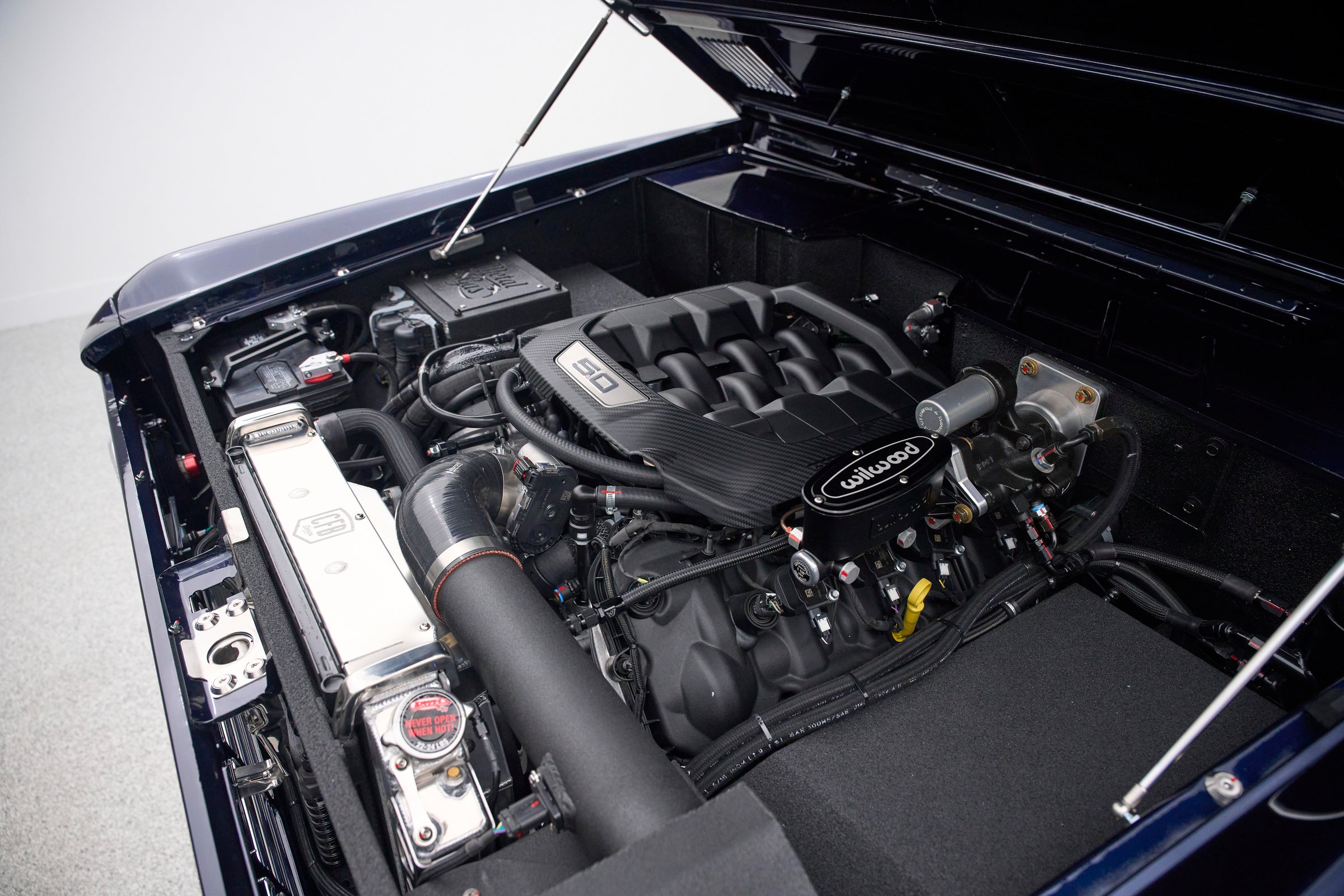 Engine bay of Classic Ford Bronco featuring modern V8 engine with Wilwood components