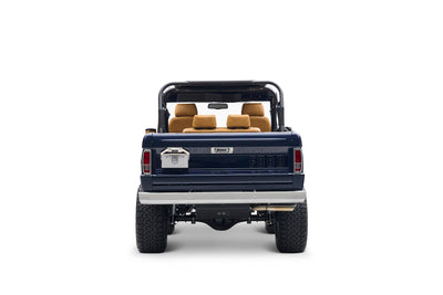 Rear view of navy blue Classic Ford Bronco with tan leather seats and open top