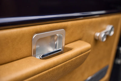 Close-up of tan door panel with chrome door handle on Classic Ford Bronco