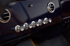 Close-up of chrome control knobs labeled lights, wipers, fan, floor, def, temp on dashboard