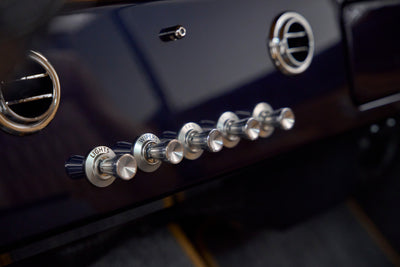 Close-up of chrome control knobs labeled lights, wipers, fan, floor, def, temp on dashboard