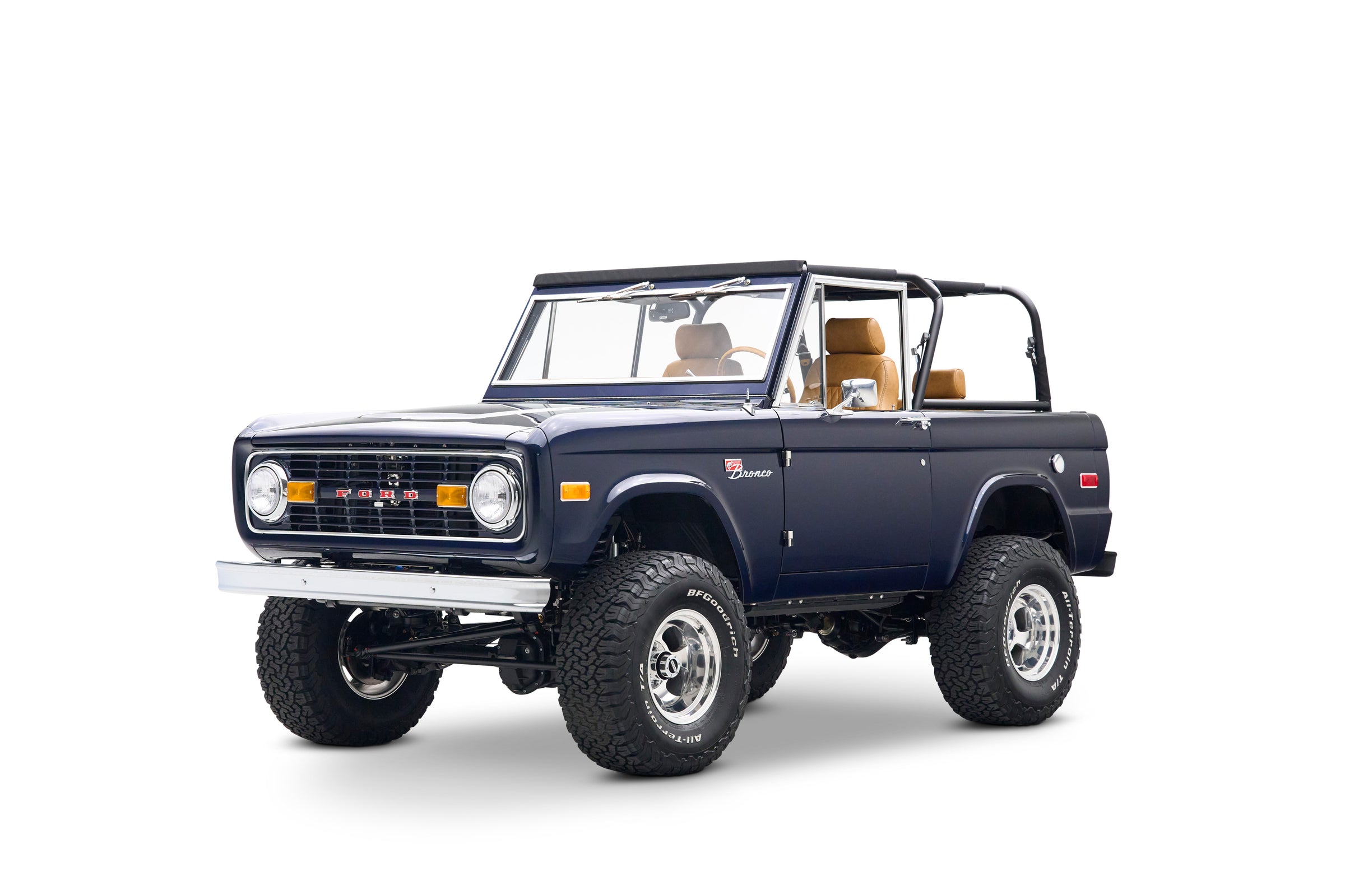 Three-quarter front view of navy blue Classic Ford Bronco, showing grille and tan interior
