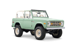 Side rear three-quarter view of Classic Ford Bronco in light green with white roll cage