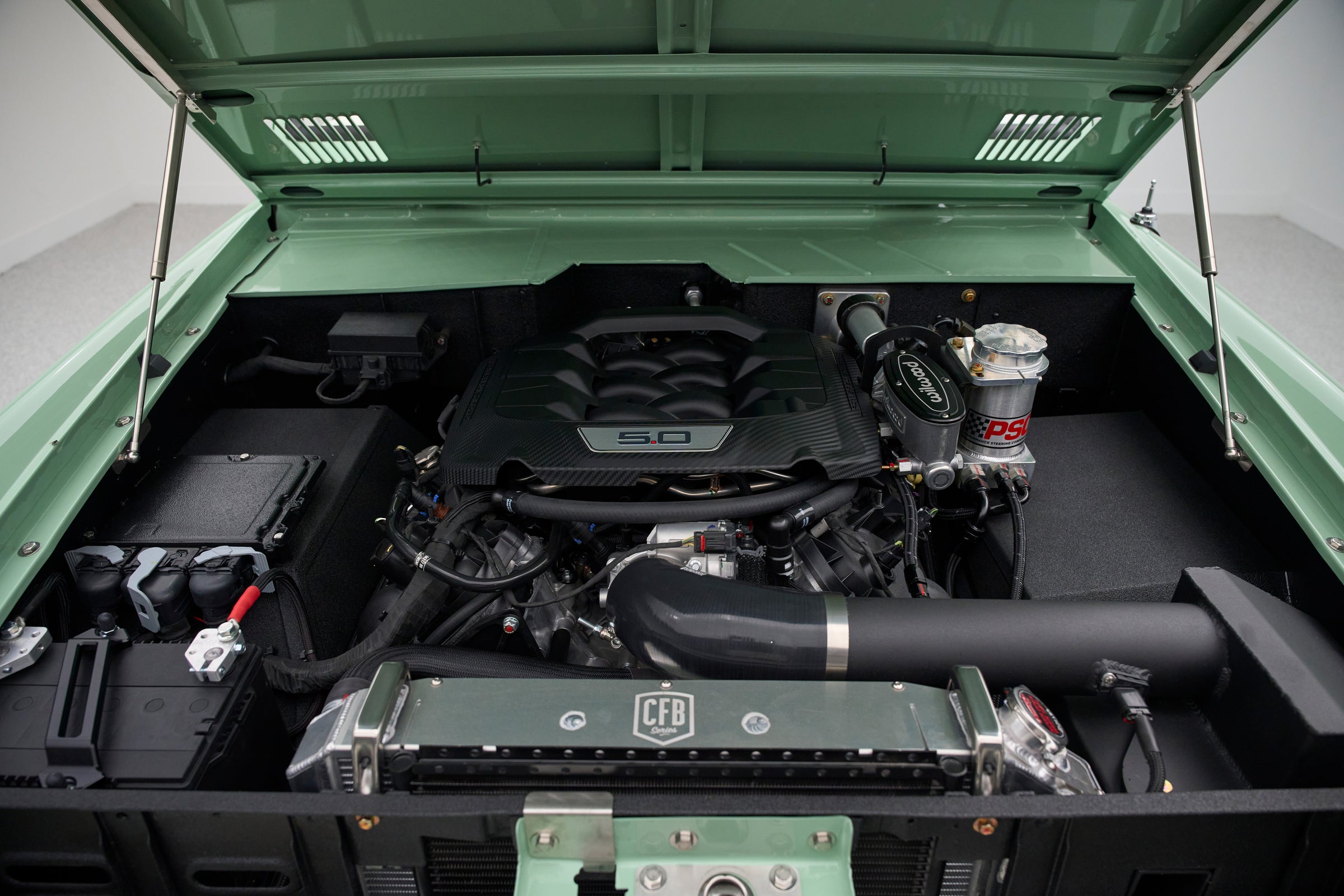 Engine compartment of classic Ford Bronco showing 5.0 liter engine.