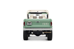Rear view of light green Classic Ford Bronco with white roll cage and visible suspension