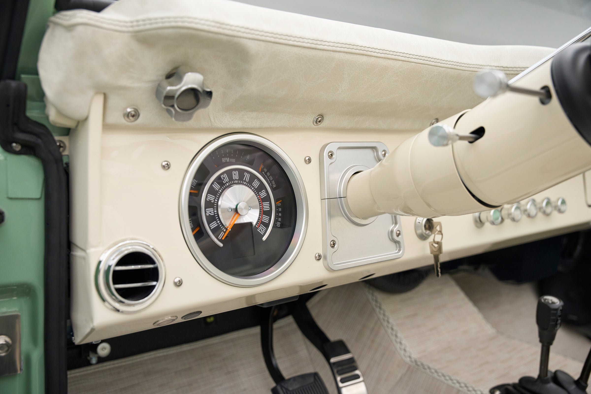 Classic Ford Bronco dashboard speedometer and air vent in cream color.