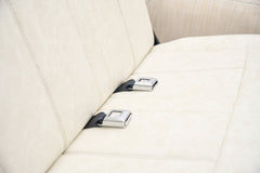Close-up of cream-colored rear bench seat with metal seatbelt buckles in classic Ford Bronco.