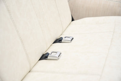 Close-up of cream-colored rear bench seat with metal seatbelt buckles in classic Ford Bronco.