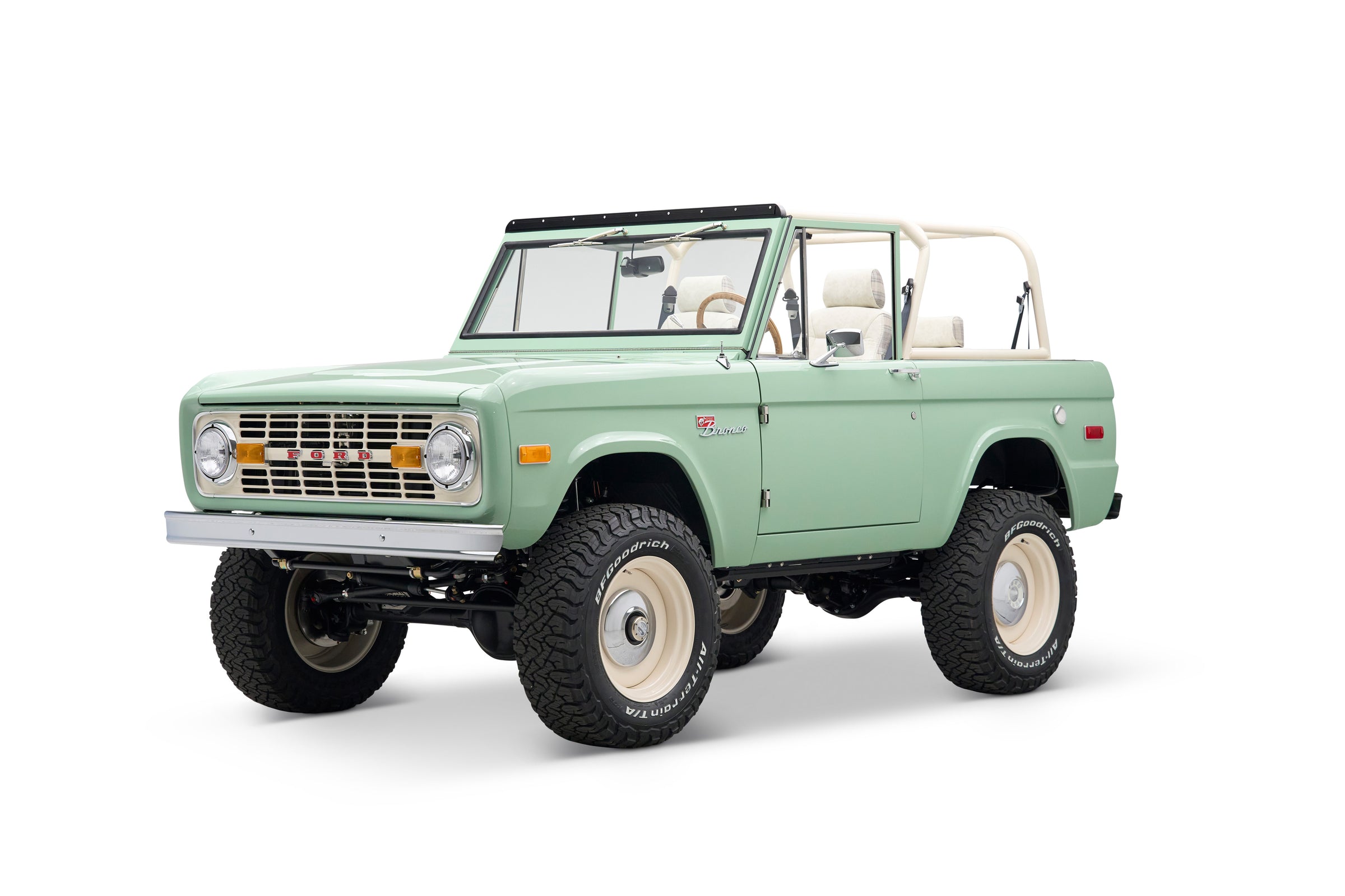 Front three-quarter view of light green Classic Ford Bronco with Ford grille and off-road tires