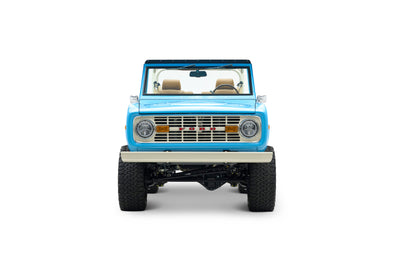 Front view of light blue Classic Ford Bronco with beige roll cage and seats