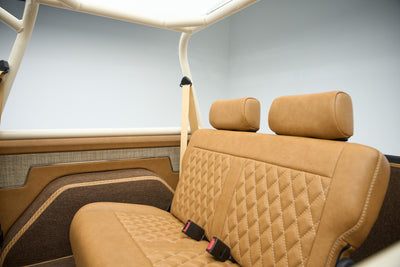Rear seats with tan leather upholstery and seat belts inside Classic Ford Bronco