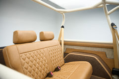 Rear tan quilted bench seat with beige seat belts inside Classic Ford Bronco