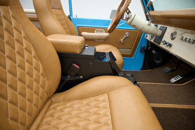 Side view of tan leather front seats with center armrest inside Classic Ford Bronco