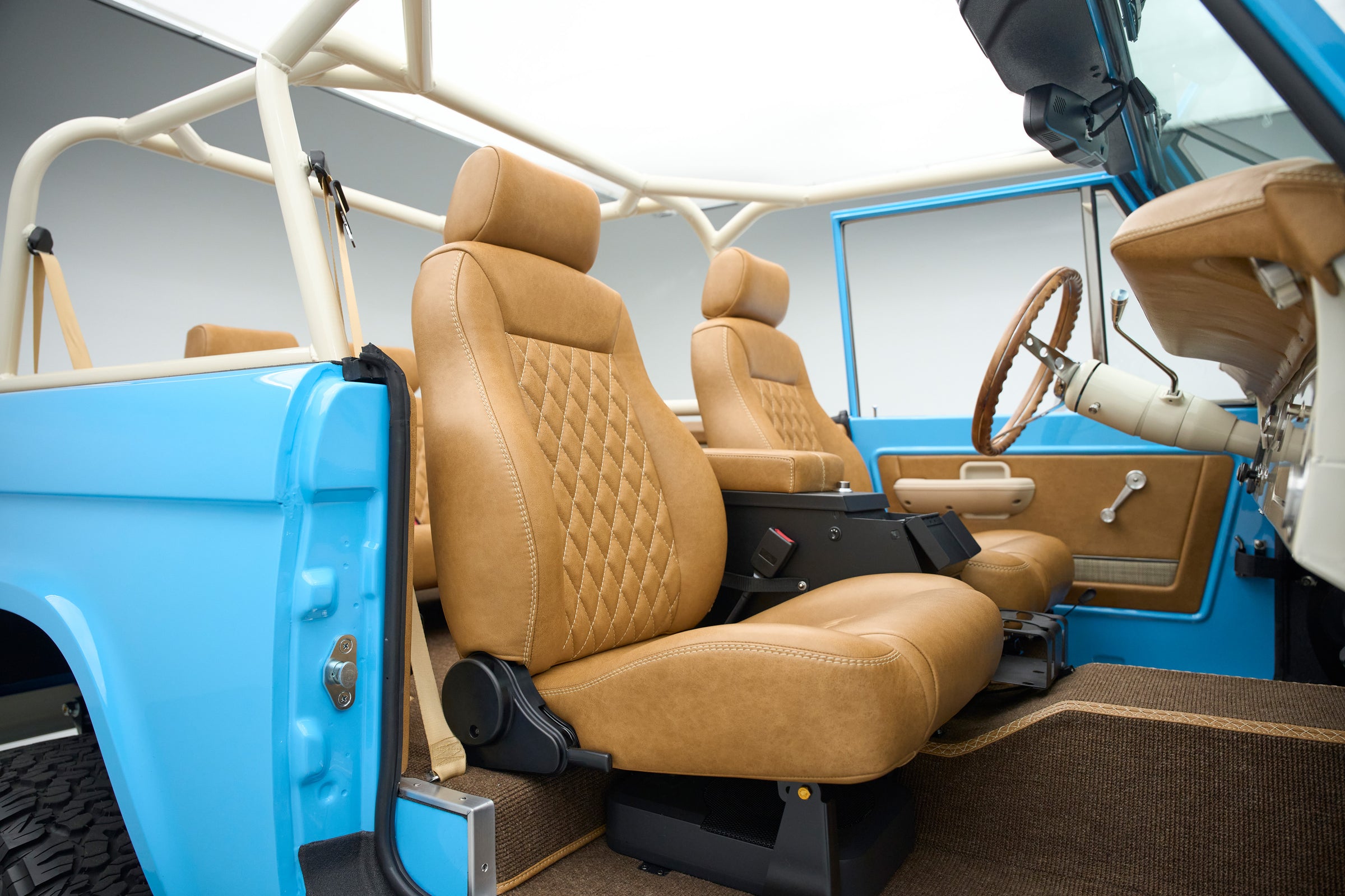 Passenger side tan leather seat and blue door panel inside Classic Ford Bronco