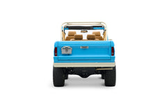 Rear view of light blue Classic Ford Bronco with beige roll cage and seats, license plate visible