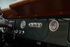 Close-up of dashboard vents and control knobs in dark green Classic Ford Bronco interior