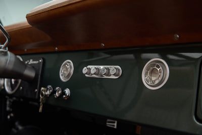 Close-up of dashboard vents and control knobs in dark green Classic Ford Bronco interior
