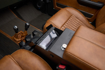 Center console and brown leather seats inside Classic Ford Bronco The Drover with 4WD shifters