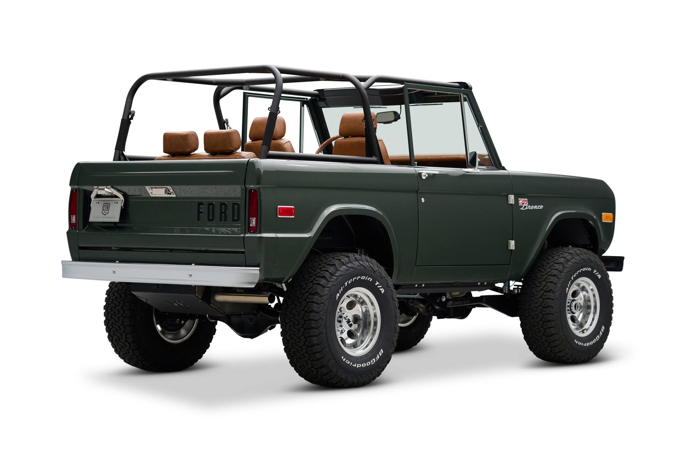 Rear three-quarter view of dark green Classic Ford Bronco with open top and roll cage