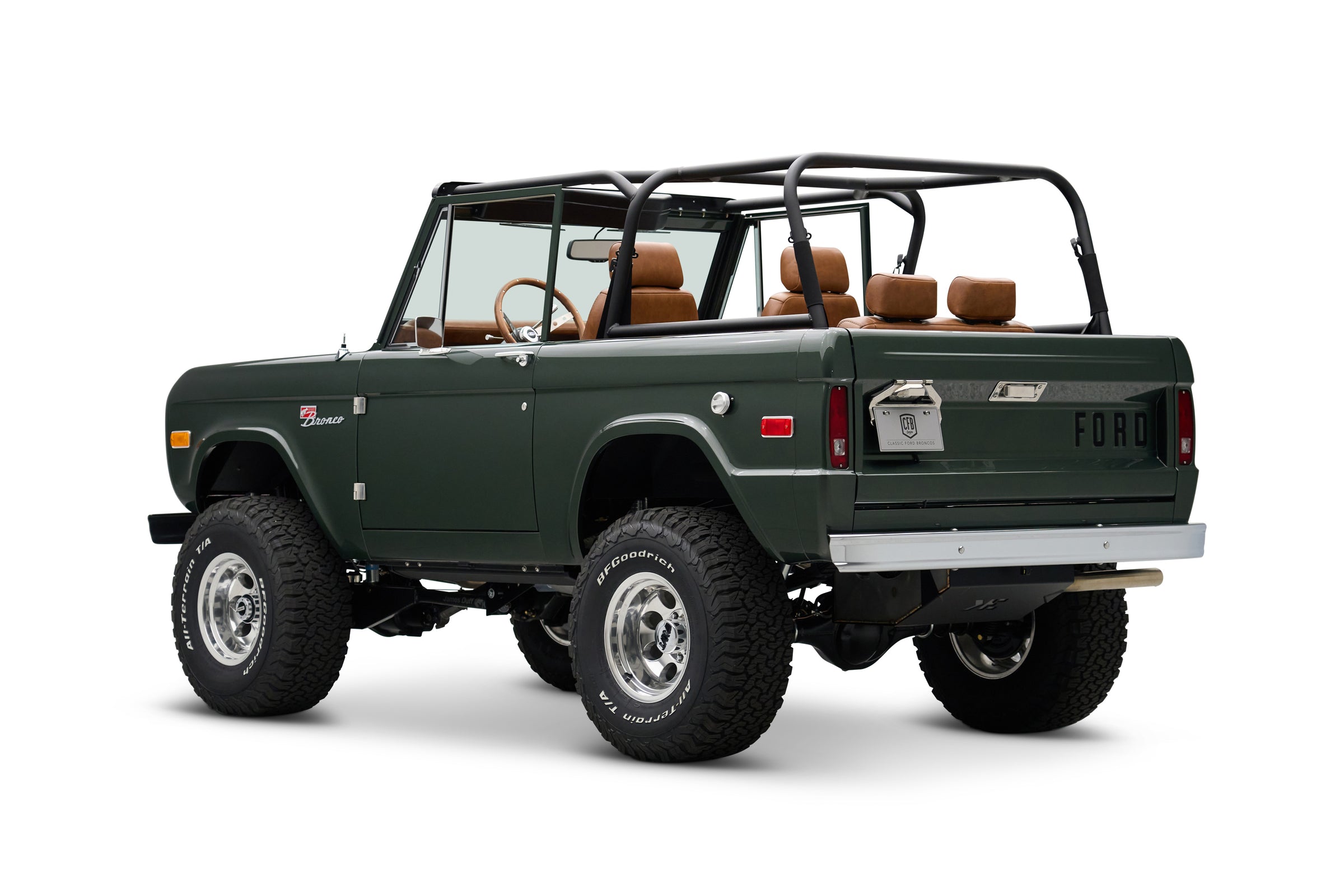 Three-quarter rear view of dark green Classic Ford Bronco with open top and tan interior seats
