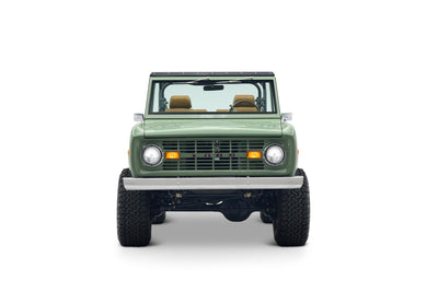 Front view of green Classic Ford Bronco The Sutton with round headlights and FORD lettering on grille