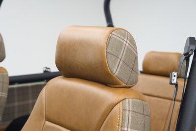 Close-up of Classic Ford Bronco seat headrest with tan leather and plaid fabric accents