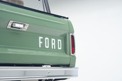 Close-up of green Classic Ford Bronco tailgate with FORD lettering and rear taillight