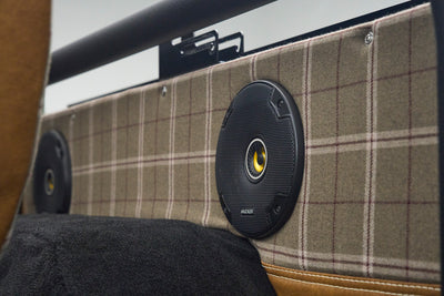 Close-up of plaid fabric and black round Kicker speaker on Classic Ford Bronco interior side panel