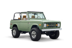 Three quarter front view of green Classic Ford Bronco The Sutton with lifted suspension and open cabin