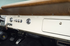 Interior dashboard area of Classic Ford Bronco with knobs, speaker, and air vents