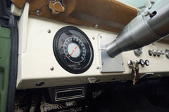 Speedometer and dashboard controls in Classic Ford Bronco with tan and green interior