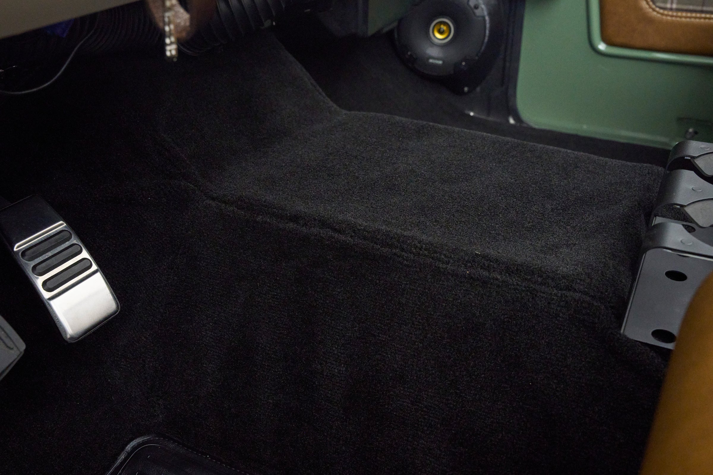 Close-up of black carpeted floor area with pedals inside Classic Ford Bronco