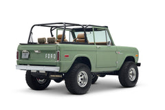 Rear three-quarter view of a green Classic Ford Bronco with open driver's door and black roll cage