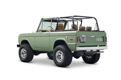 Rear three-quarter view of a green Classic Ford Bronco showing Ford logo on tailgate and plaid seats
