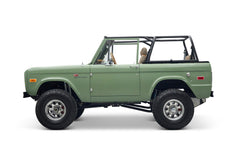 Side view of green Classic Ford Bronco The Sutton showing front door and lifted off-road tires